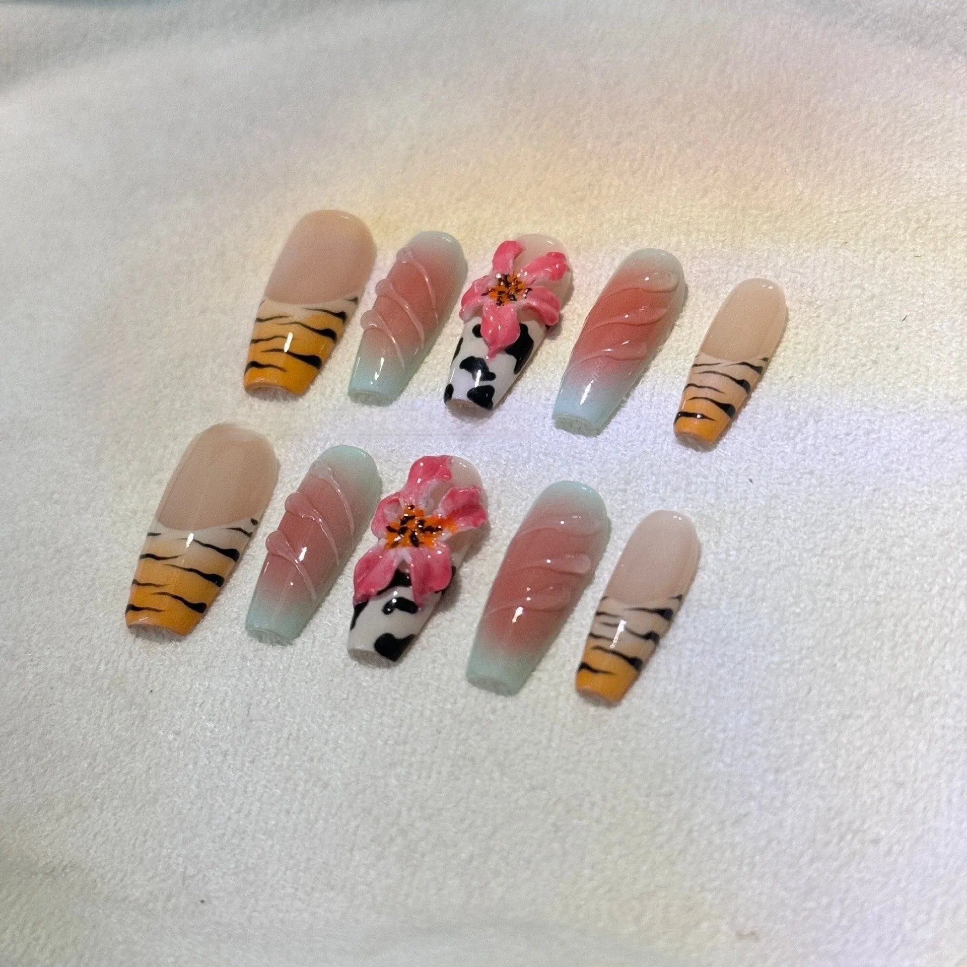 Hand-carved zebra pattern lily nail art set showing floral, leopard print and embossed designs in multiple sizes