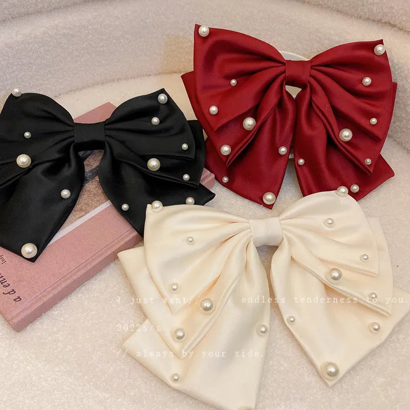 Pearl bow hair clip in black, red or beige with cloth, faux pearl and alloy construction