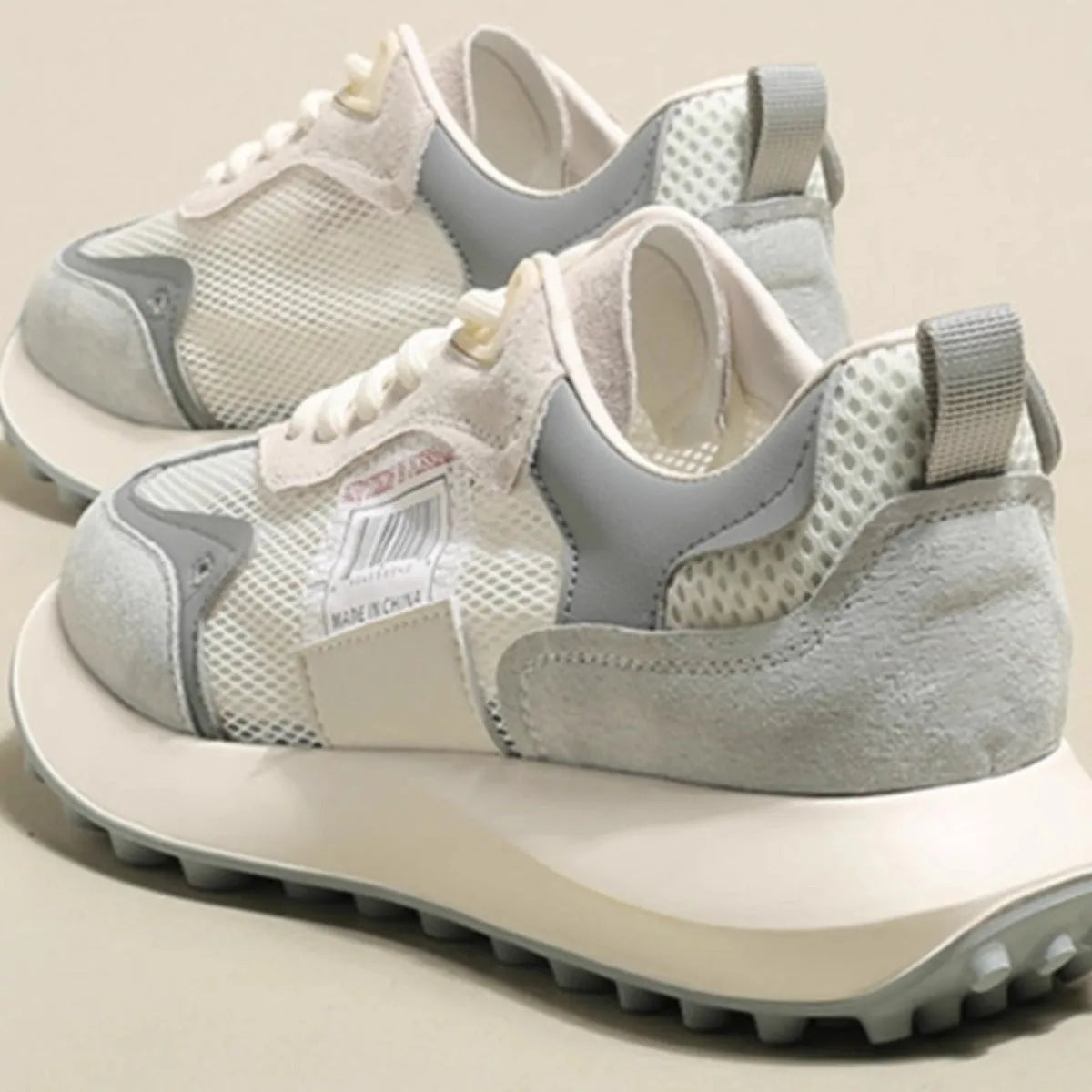 Women's gray retro sneaker with mesh lining and rubber sole on wooden floor