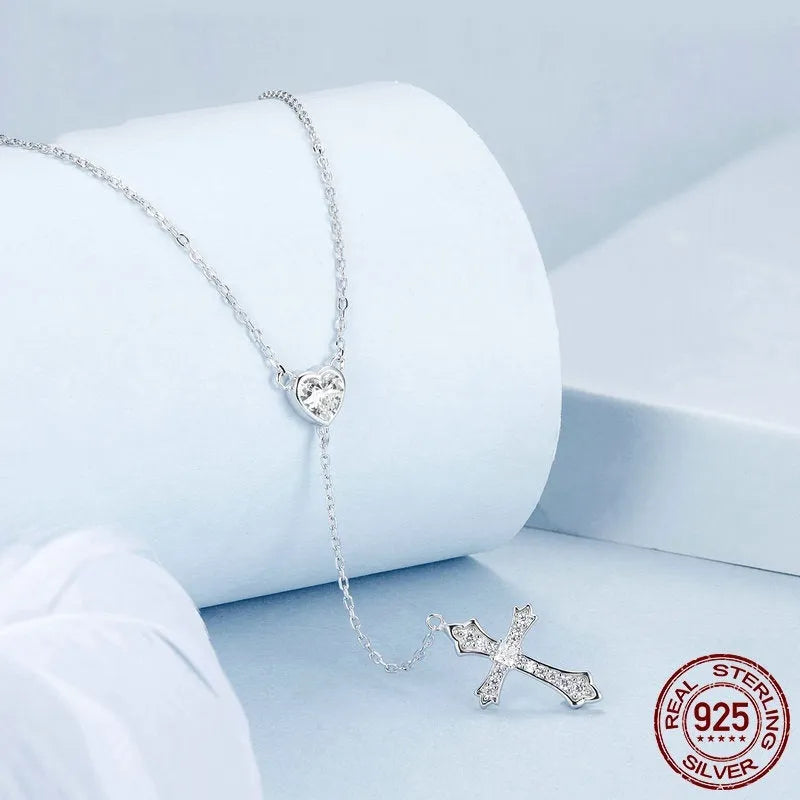 Simple silver love cross necklace on a V-neck O-ring chain for women.