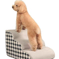 Wooden pet climbing ladder with fabric steps in orange bear plaid pattern beside a bed