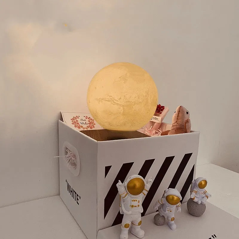 Maglev moon and planet LED night light floating above base with three astronaut figures nearby.