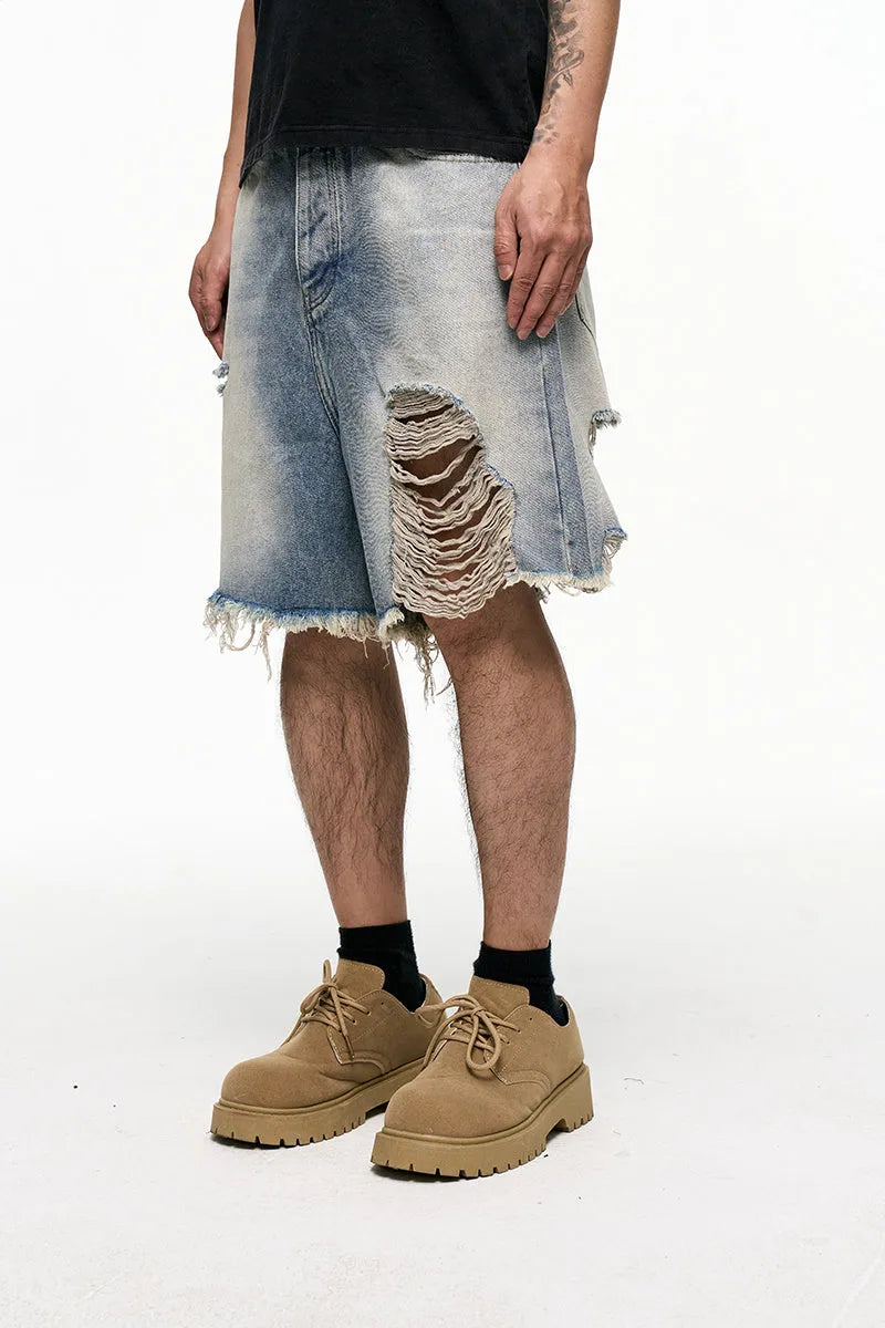 Men's light blue baggy denim shorts on a mid-waist mannequin, showing wide leg cut and zipper fly.