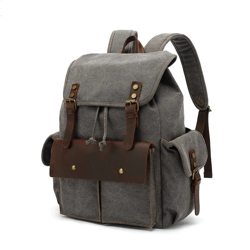 Retro-style canvas backpack in military green with antique bronze hardware, shown with a 16-inch laptop.