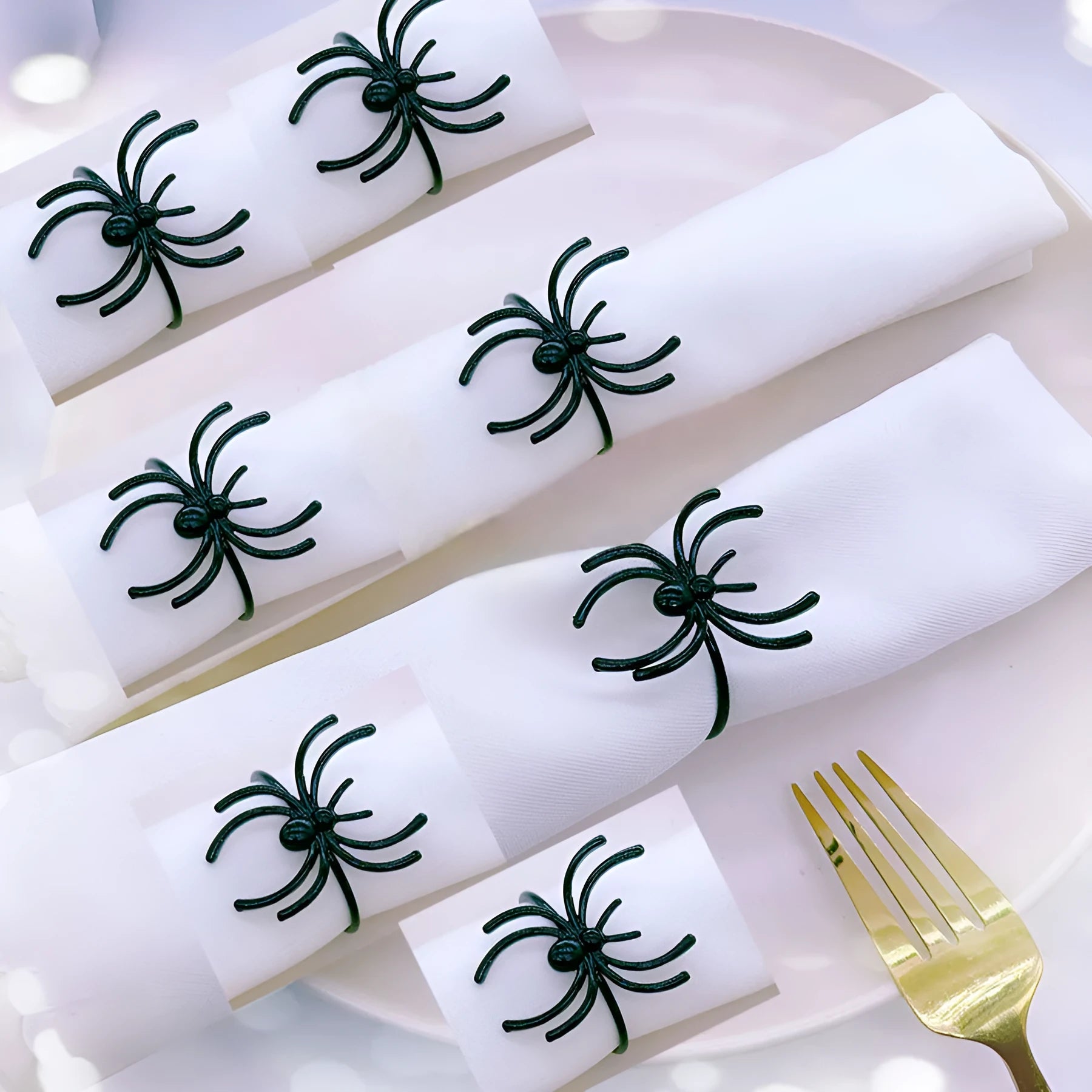 Six black alloy spider-shaped napkin rings for Halloween table decoration.