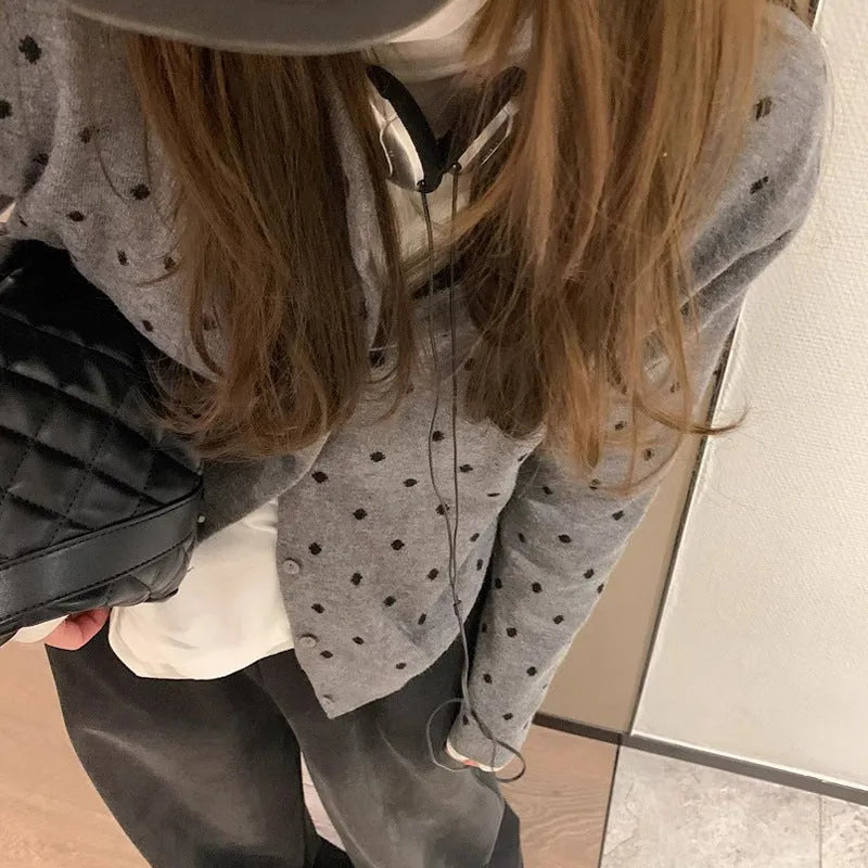 Women's loose-fit gray dot patterned knitted cardigan in black, showcasing crocheted flower detail.