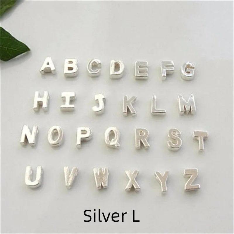 Gold heart shaped alloy pendant with initial letter on white background