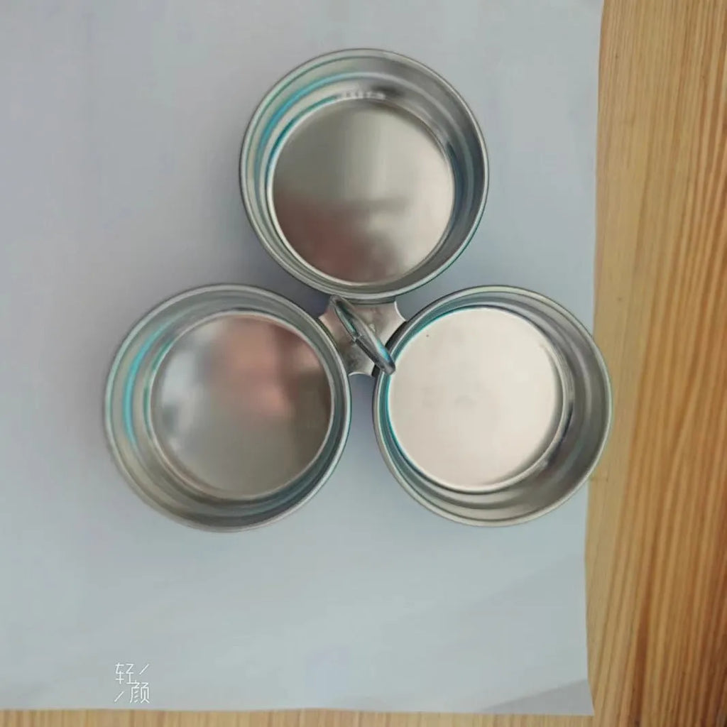 Stainless steel heart-shaped egg steamer next to a round model on a kitchen counter.