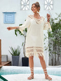 Apricot coloured long hand-crocheted beach dress on a hanger.
