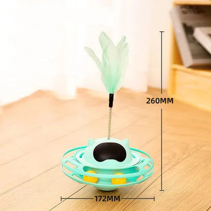 Pink plastic cat tumbler turntable toy with stick and ball on a flat surface.