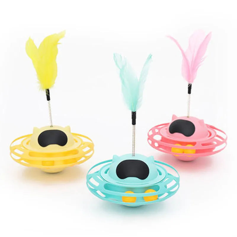 Pink plastic cat tumbler turntable toy with stick and ball on a flat surface.