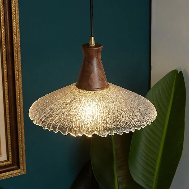Retro wooden ceiling lamp with brass details and glass shade shown in a dining setting