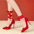 Women's black pointed toe high heels with lace strap and buckle closure