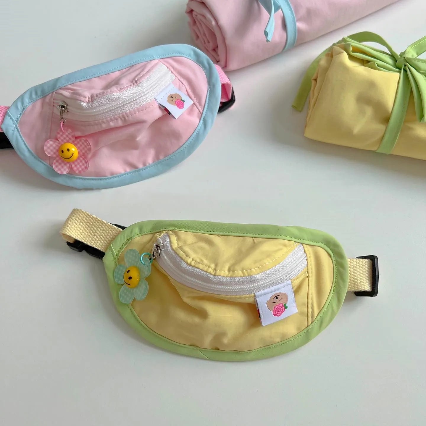 Powder blue, yellow and green backpack-style pet poop bag holder with adjustable shoulder strap