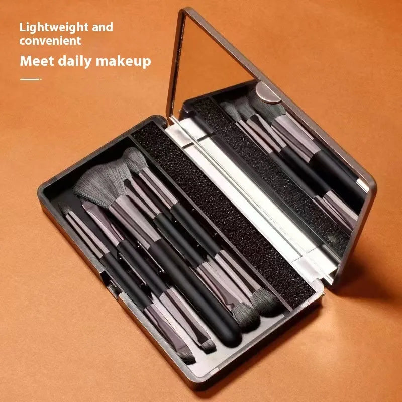 Makeup brush set with mirror showing silver or gold finished brushes with artificial fibre bristles