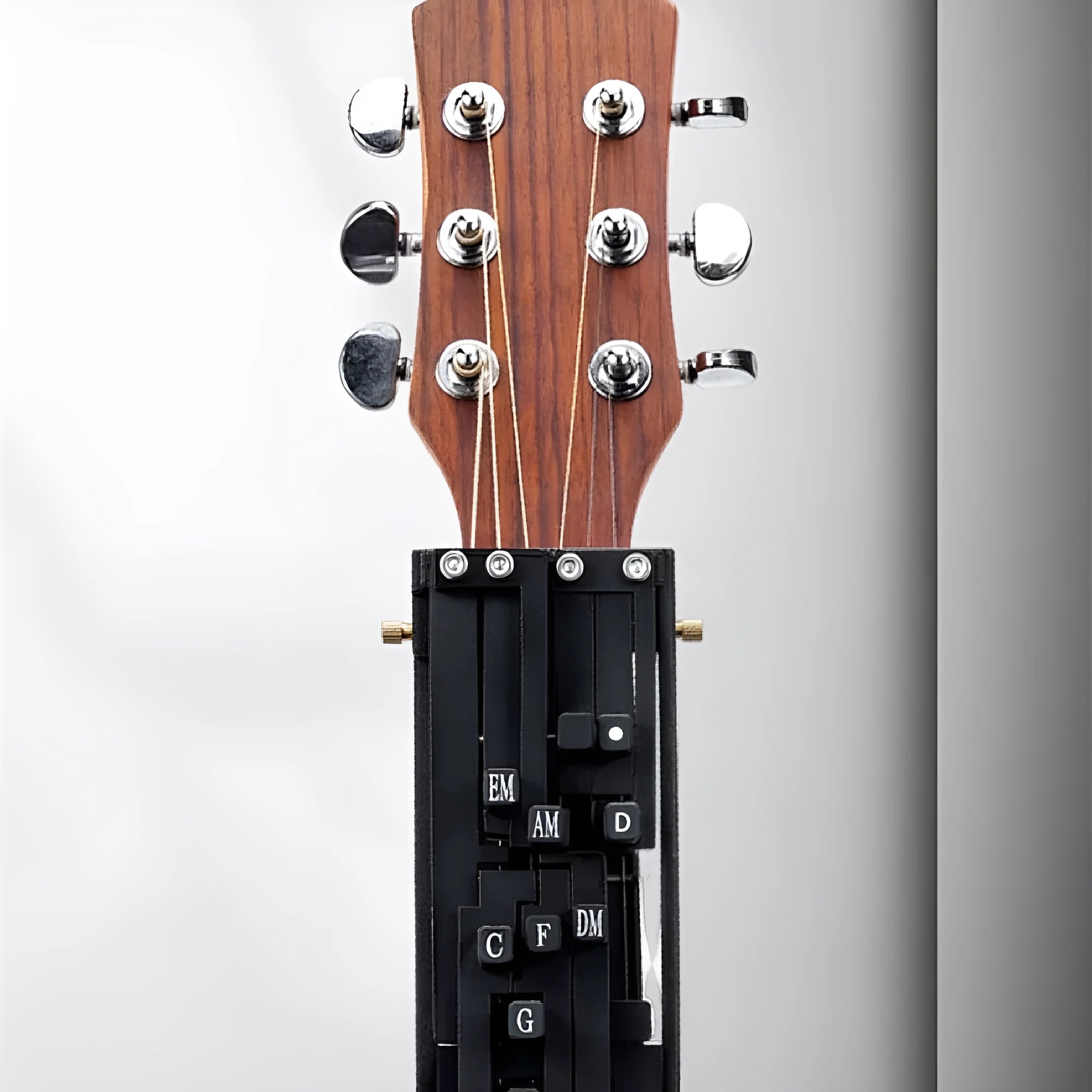 Black automatic guitar chord capo device on guitar neck for beginner practice