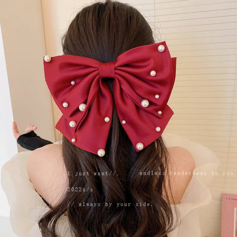 Pearl bow hair clip in black, red or beige with cloth, faux pearl and alloy construction