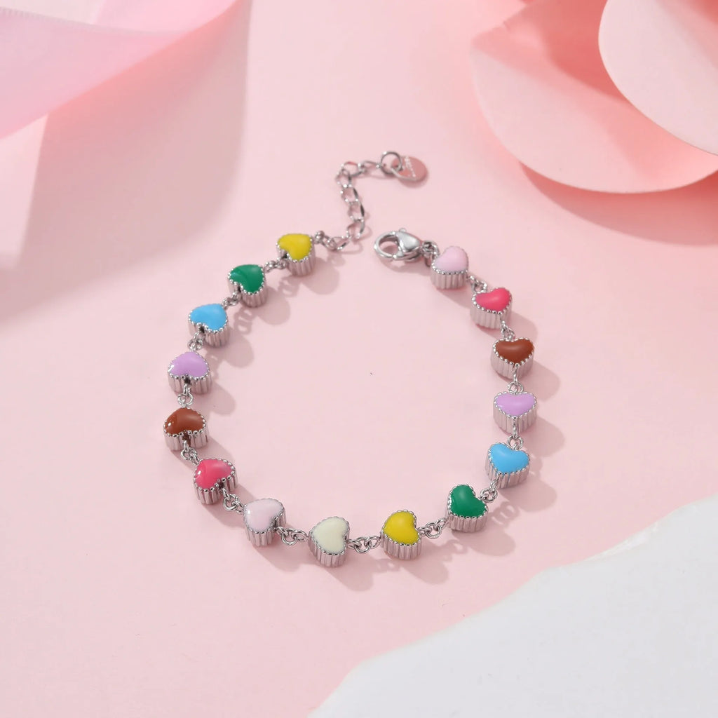 Close-up of a women's stainless steel bracelet with a colourful, heart-shaped titanium steel pendant.
