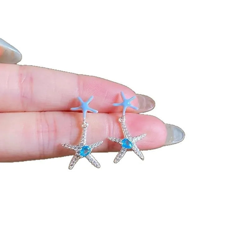 Blue zircon starfish stud earrings in a silver-tone setting with a compact design.