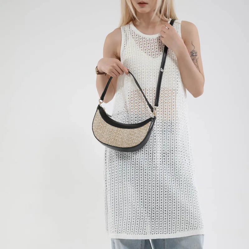 Hard straw women's crossbody dumpling bag in black with contrast stitching and single shoulder strap.