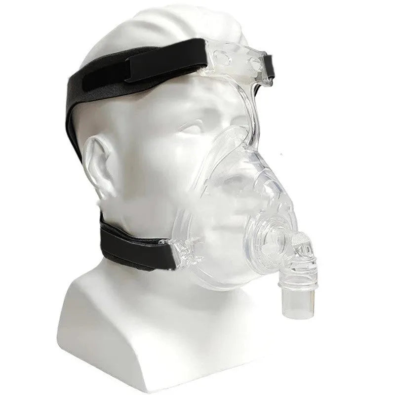 Transparent silicone CPAP breathing mask with headband and two adapter elbows on a white background.
