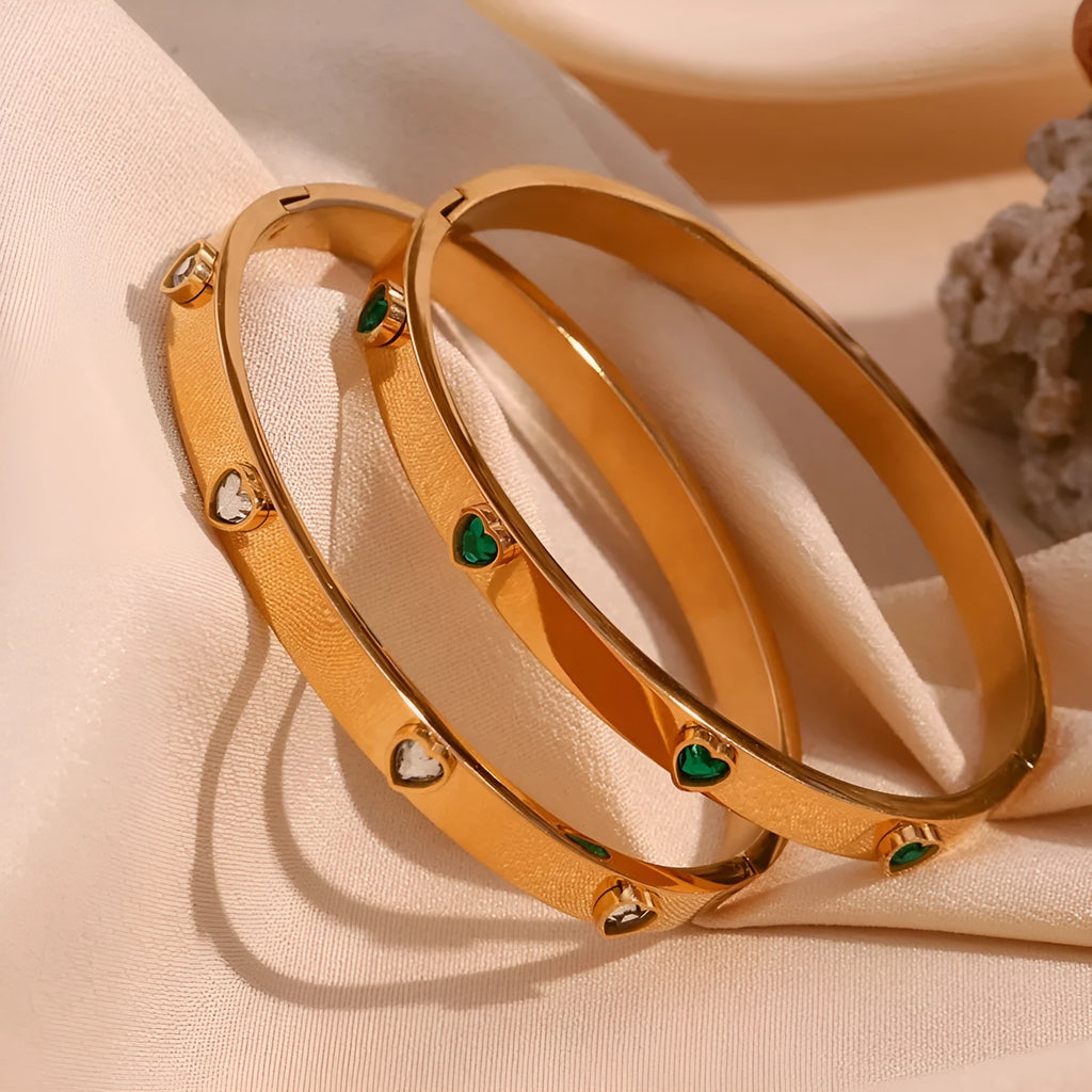 A stainless steel bracelet with a micro-inlaid peach heart charm in green or white diamond colour.