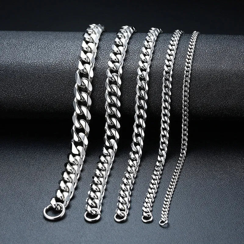 Six-sided Cuban link metal bracelet in gold, black, and steel colour finishes on a wrist.