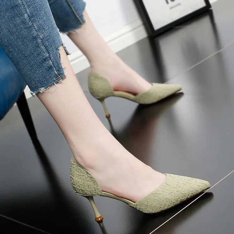 Women's black pointed toe stiletto high heels with a thin heel on a plain background.