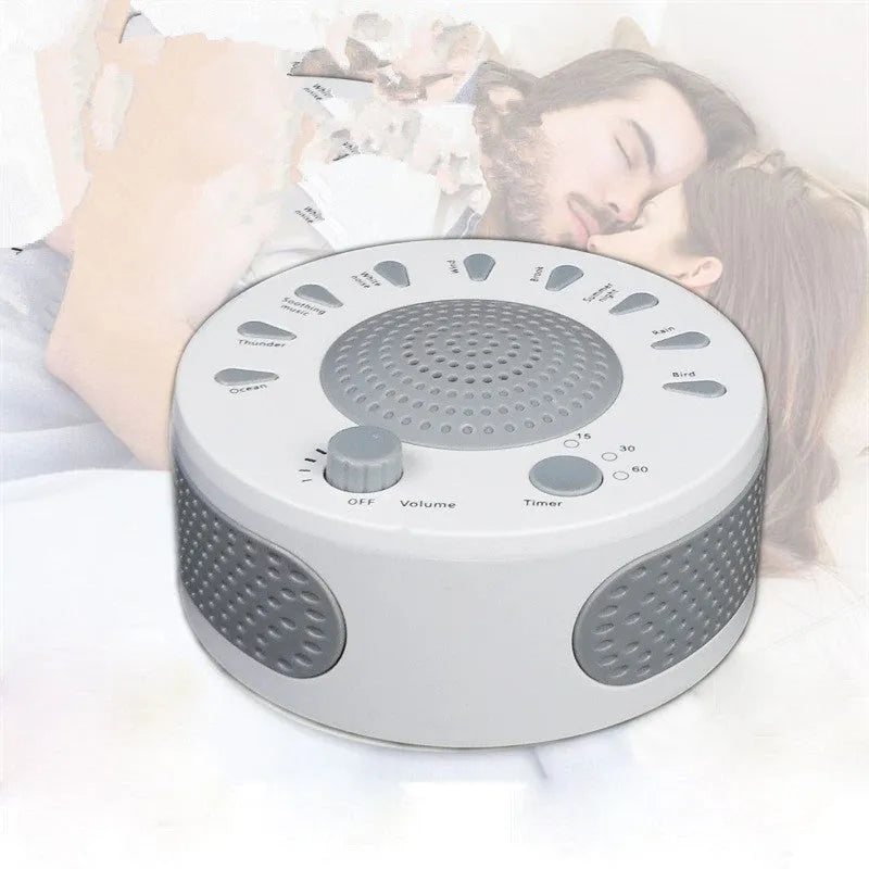 White noise sleep machine with volume knob, showing white colour option, beside USB cable on table