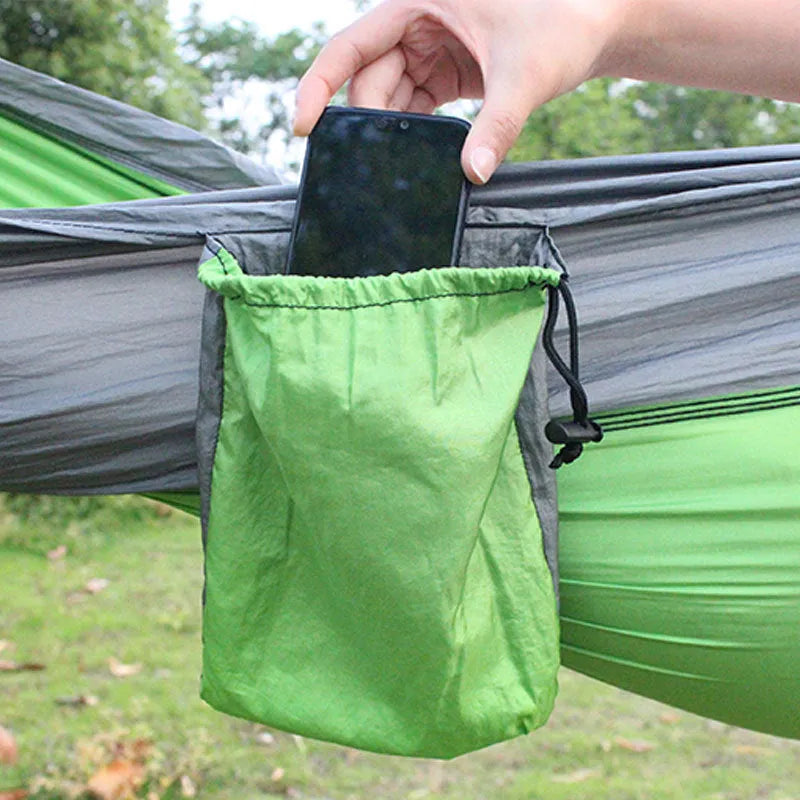 Blue nylon parachute cloth camping hammock hanging between two trees, showing its full 270cm length.
