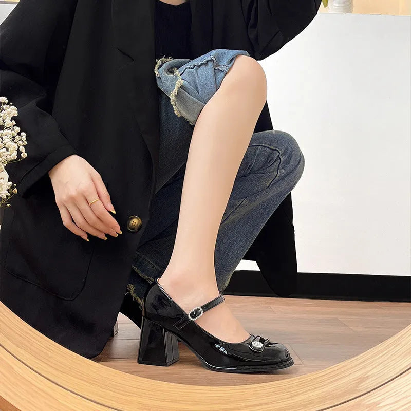 Women's black patent leather chunky heel shoes with round toe and buckle, shown in a larger size.