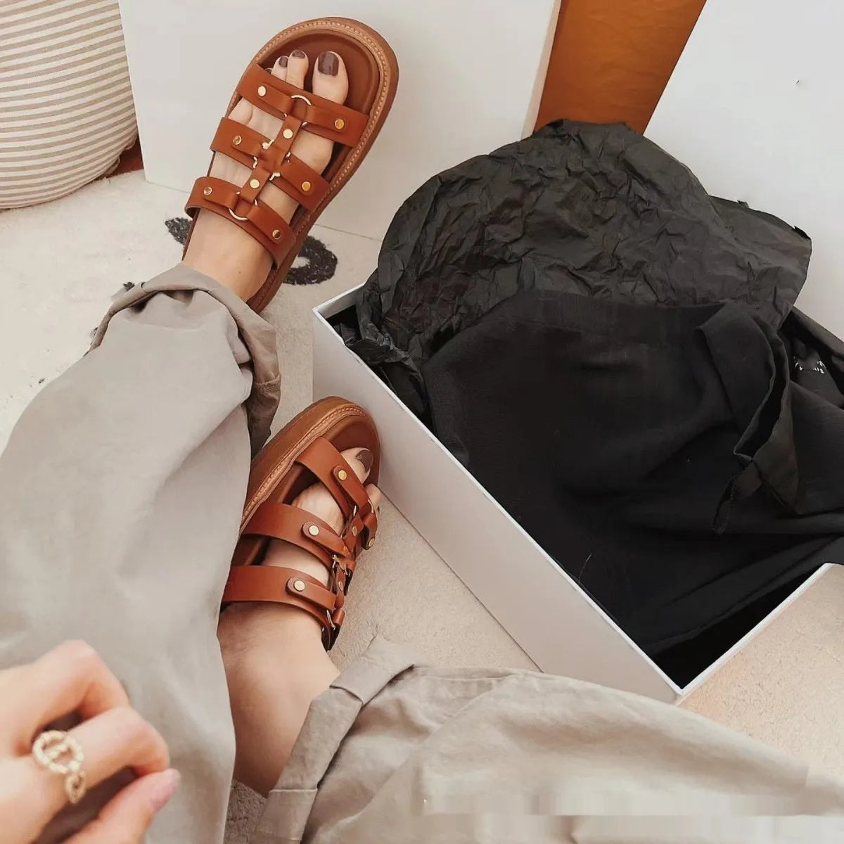 Women's white patent leather Roman style sandal slippers with sheepskin upper on a neutral background.