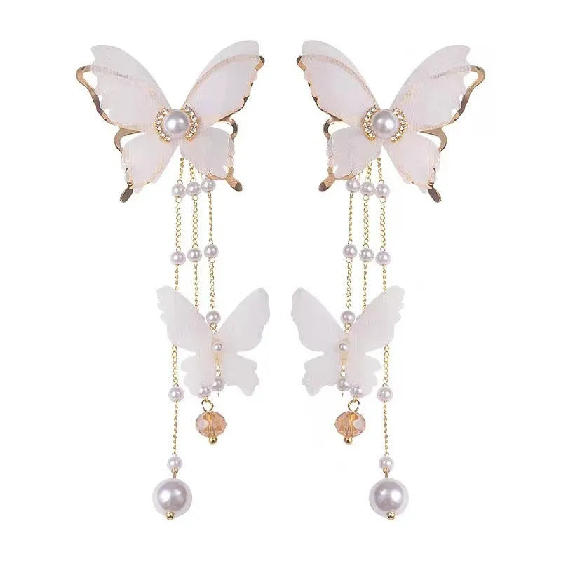 Butterfly shaped white earrings with tassel lace design and pearl rhinestone accents on copper alloy