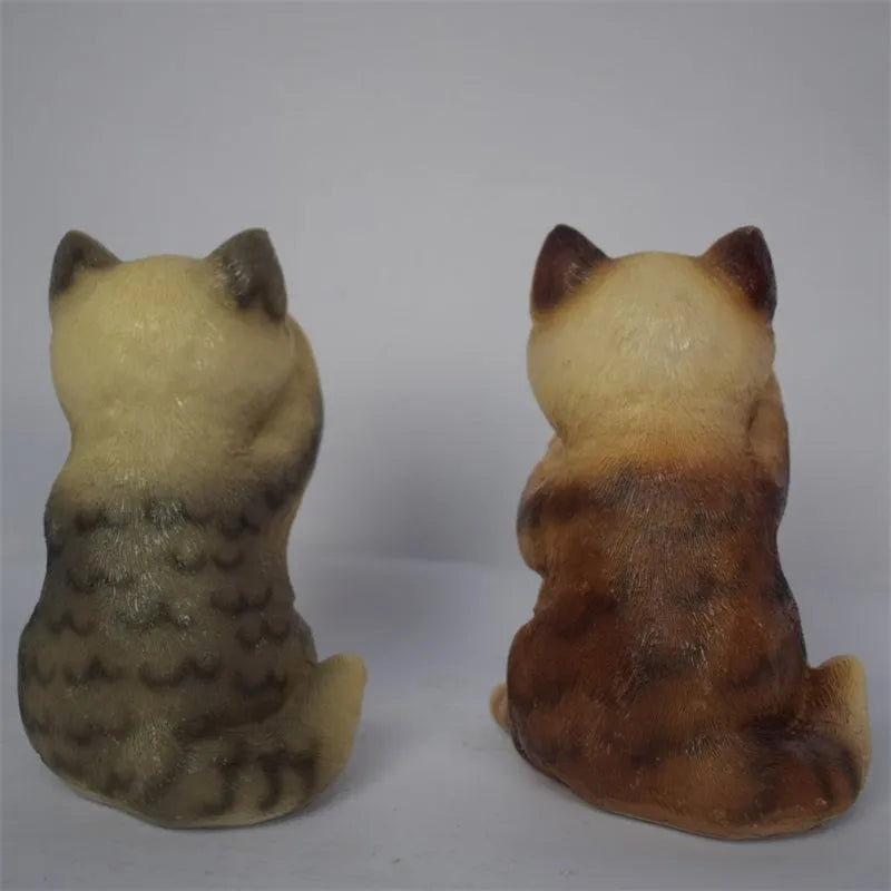 Brown resin cat-shaped solar garden light with LED on a lawn.