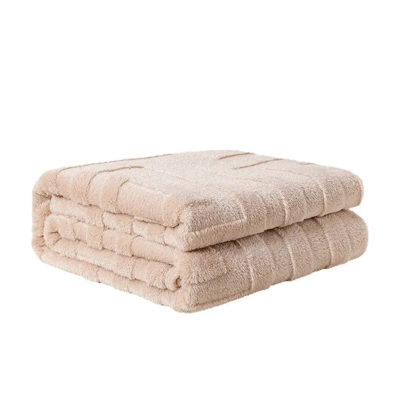 A square thick coral fleece blanket in a solid colour or floral pattern, shown draped over a sofa.