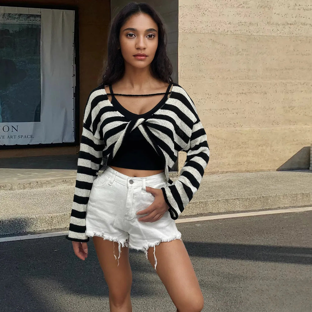 Black and white striped long-sleeved sweater worn as a pullover with an exposed navel style detail.