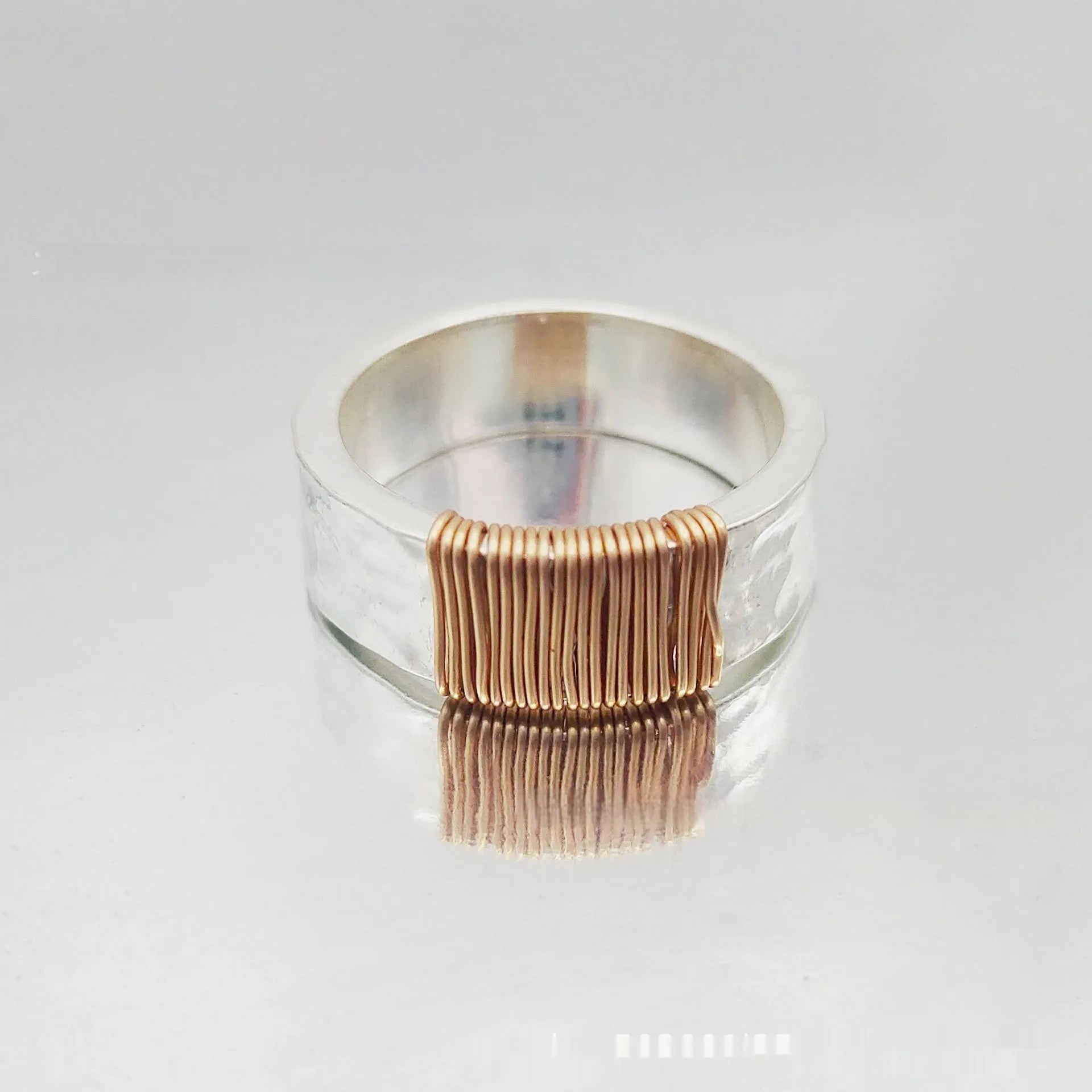 Geometric wide face copper bracelet ring with irregular coil design in silver gold finish.