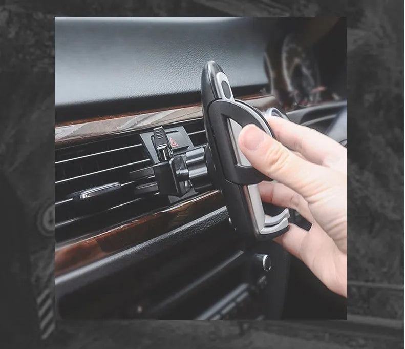 Black plastic car mobile phone holder mounted on air conditioning vent holding smartphone