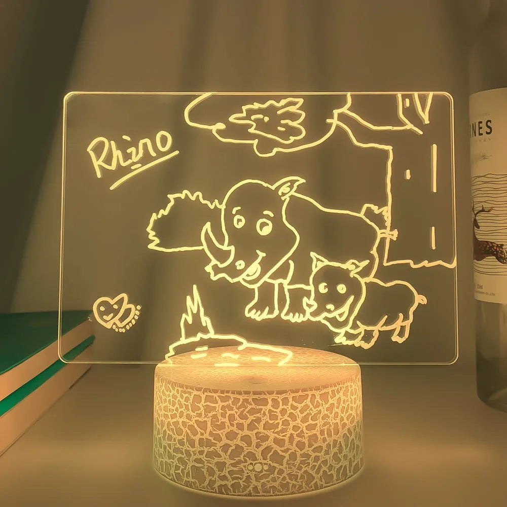 Black 3D acrylic LED night light and message board with stylus on a desktop