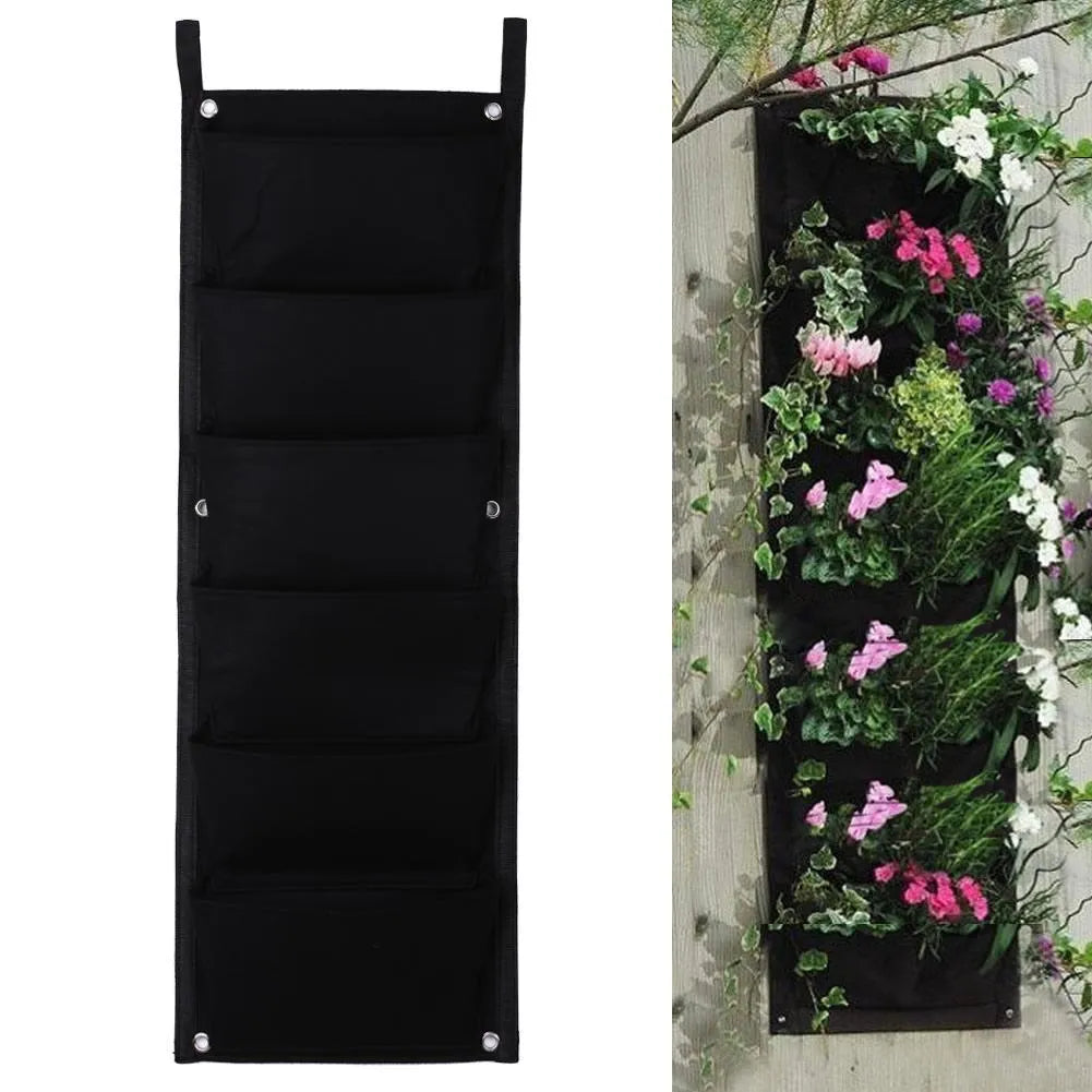 Vertical 7-pocket felt planter bag hanging on a wall with green plants growing from the pockets