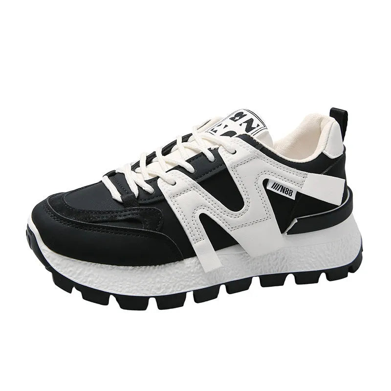 Low top unisex running sneaker in black or white with round toe and flat rubber sole.