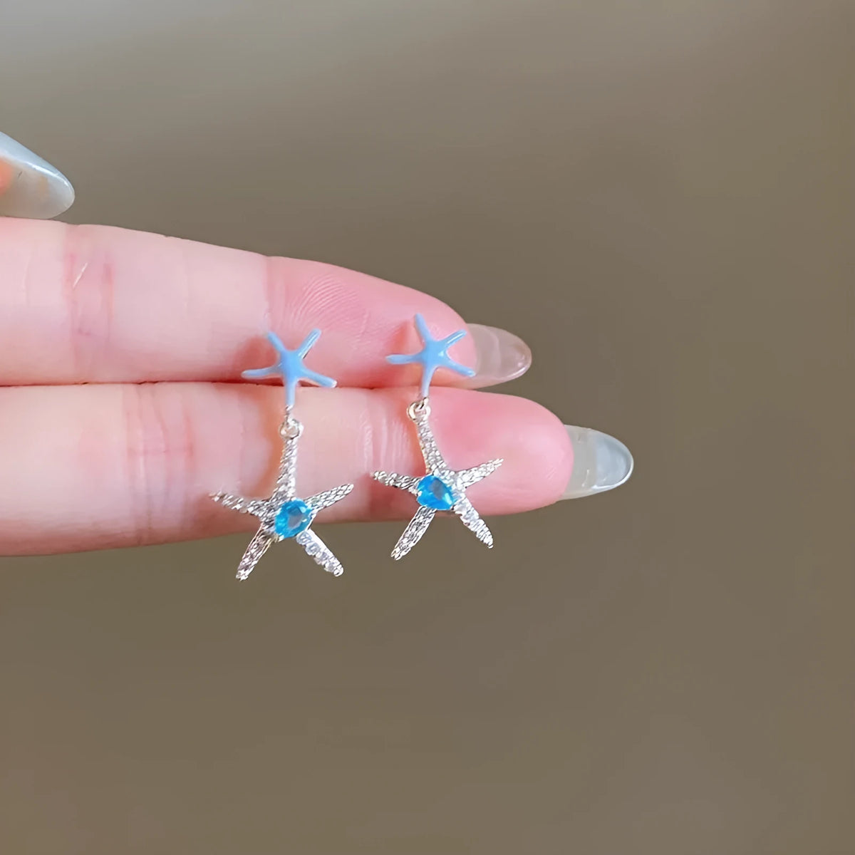 Blue zircon starfish stud earrings in a silver-tone setting with a compact design.
