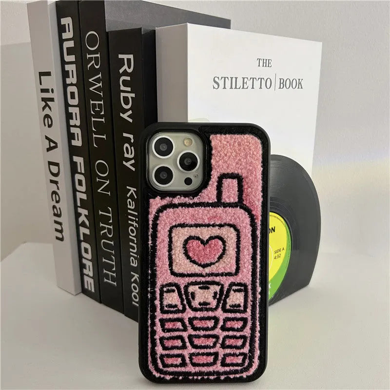 Pink towel embroidered soft TPU case for iPhone on a table.
