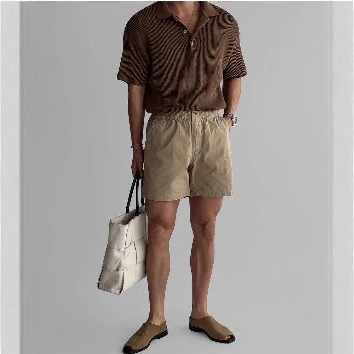 Men's loose-fit cotton sports shorts in black, shown on a model.