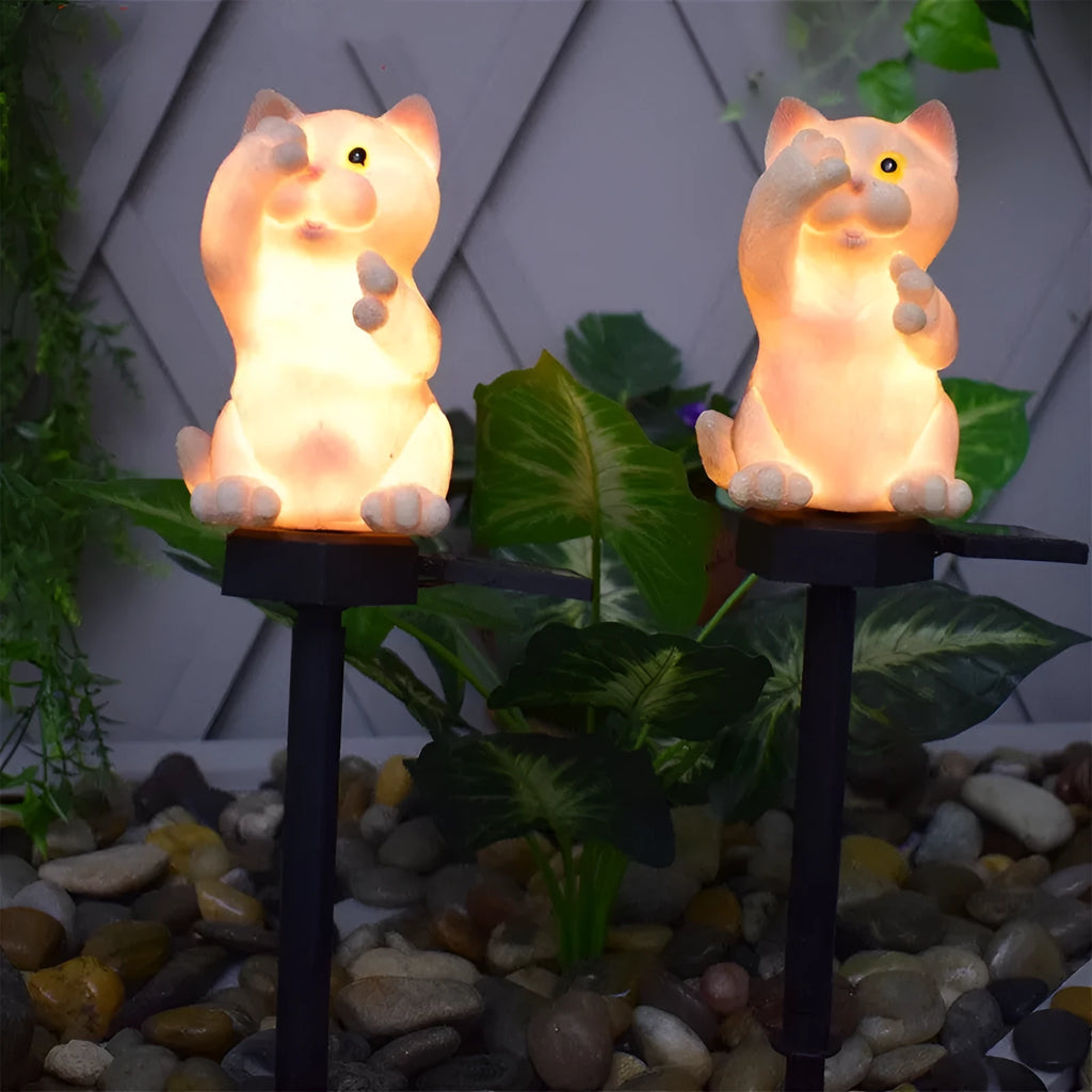 Brown resin cat-shaped solar garden light with LED on a lawn.
