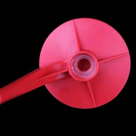Red plastic soda dispenser attached to 2-litre bottle showing push-button mechanism