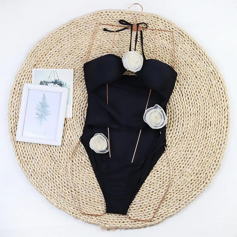 Women's black and blue striped one-piece swimsuit with 3D floral design on the front.