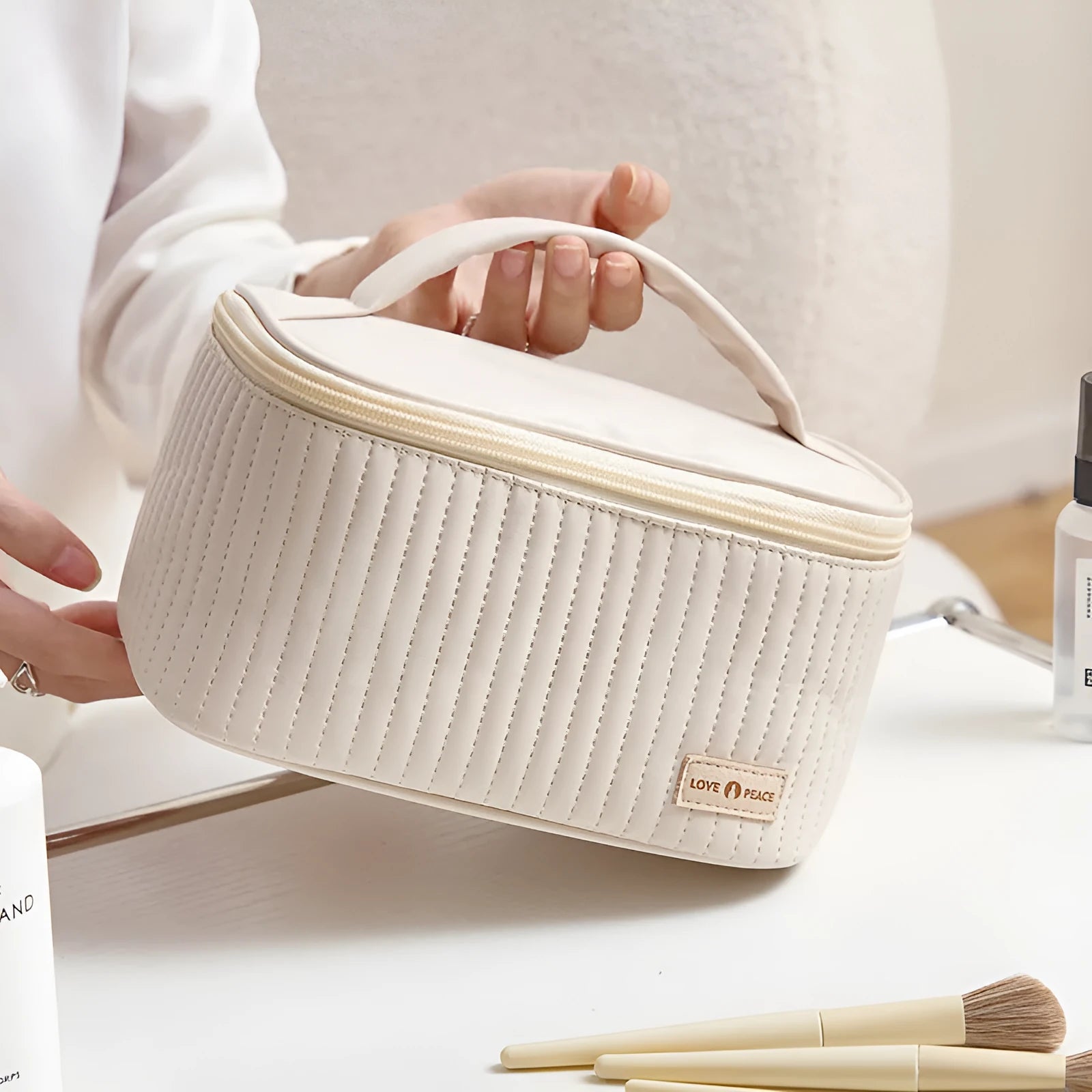 Open-top round pink PU leather makeup bag with a flat bottom on a table.