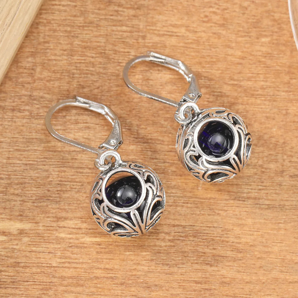 Women's geometric earrings with vintage engraving and hollow blue gemstone pendants in silver colour