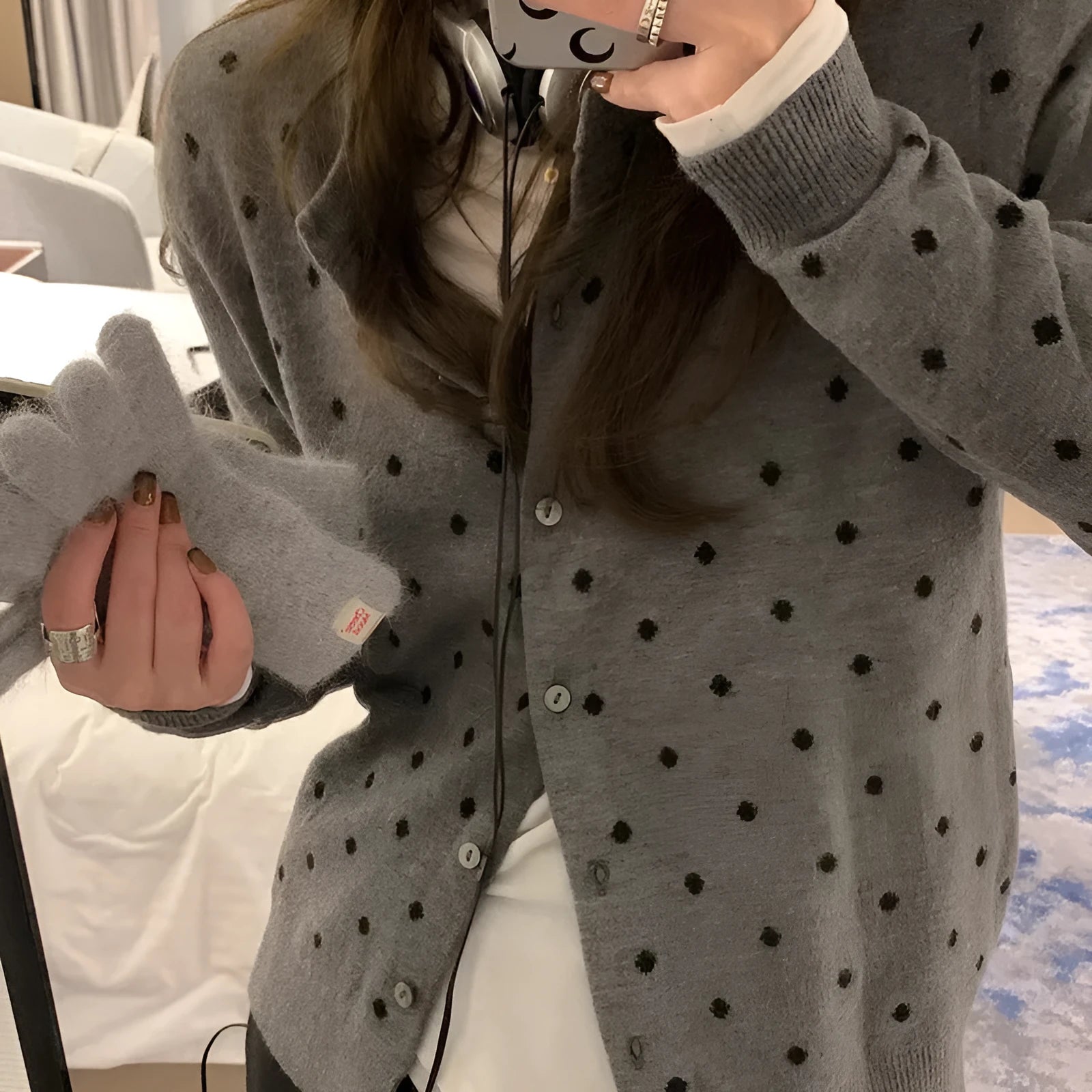 Women's loose-fit gray dot patterned knitted cardigan in black, showcasing crocheted flower detail.
